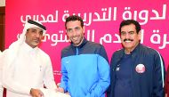 Fahad Thani Al Zaraa, Director of the Development Department at QFA, giving away certificate to a participant in Doha yesterday. 