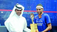 Nasser Ghanem Al Khelaifi, President of Qatar Tennis, Squash and Badminton Federation (QTSBF), hands Qatar Classic trophy to Mohamed El Shorbagy after he defeated Tarek Momen in the all–Egyptian final at Khalifa International Tennis and Squash Complex yes