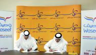 Faleh Al Naemi, Chairman and Managing Director of Qatar Post; and Hamad Rashed Al Kuwari, CEO of Waseef Company, during the MoU signing. 
