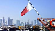 A combination photo of Qatar flag along Corniche and Japan flag on the Bank of Japan building in Tokyo. 