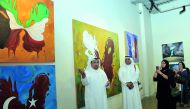 Nasser Al Attiya (left) talks about some of his paintings while Khalifa Al Obaidli (centre), Director of the Fire Station looks on, at the opening of Al Attiya’s exhibition at Doha Fire Station on Monday. Pic: Kammutty VP/The Peninsula