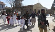 Pakistani Christian children are evacuated by security personnel from a Methodist church after a suicide bomber attack during a Sunday service in Quetta on December 17, 2017.  AFP / BANARAS KHAN
