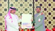 Ahmed Al Henzab, Head of Administration & Property Department at Doha Bank, receives a trophy and a plaque of appreciation on behalf of Doha Bank from Hassan AL-Ajmi from the Qatar National Day Celebrations Organising Committee at Darb Al Saai during a sp