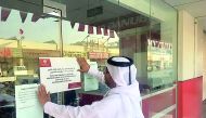 A Ministry official affixing the closure notice.
