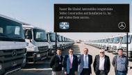 Senior officials from NBK and Tekfen posing with a fleet of Mercedes-Benz Actros trucks.