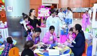Parents with kids at Al Wakrah Hospital getting information from healthcare professionals about the new play therapy programme introduced by HMC. 