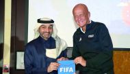 Former Italian referee Pierluigi Collina (right) presents a souvenir to Hani Balan, Chairman of the Qatar Referees Committee and Vice-Chairman of the FIFA Referees Committee on Monday.