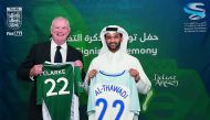 English Football Association Chairman Greg Clarke and Supreme Committee for Delivery & Legacy (SC) Secretary General H E Hassan Al Thawadi hold football jerseys.