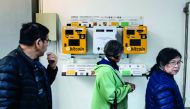 Pedestrians walk past ATM machines for digital currency Bitcoin in Hong Kong on December 18, 2017. (AFP / Anthony Wallace) 