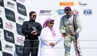 Podium winners at the Fourth Round of Qatar Touring Car Championship receiving  their prizes from an official at Losail International Circuit on Saturday.