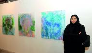 Qatari artist Ebtissam Al Saffar poses with her paintings at the opening of “Perspectives-Contemporary Arab Women Artists” at the Art 29 at W Hotel in Doha yesterday. Pic: Salim Matramkot/The Peninsula