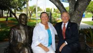Wayne and Marti Huizenga sit  next to a new Huizenga bronze statue (Photo courtesy: nsunews.nova.edu) 