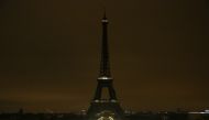 The lights of the Eiffel Tower are dimmed at midnight, March 23, 2018 in Paris to honor victims killed at a supermarket in southwest France by a man claiming allegiance to the Islamic State. AFP / Zakaria ABDELKAFI