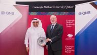 Michael Trick, Dean of Carnegie Mellon University in Qatar, is presenting a memento to Ali Ahmed Al Kuwari, Group CEO of QNB.