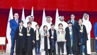 Sheikh Faisal bin Qassim Al-Thani (third left), the Chairman  and Founder of AlFaisal Without Borders Foundation, and other dignitaries with students at the closing ceremony of the Second Education Festival.