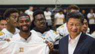 Chinese President Xi Jinping receives a football jersey bearing his name as he visits Lincoln High School in Tacoma, Washington. (Reuters) 