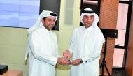 Jamal Abdullah Al Jamal (right), QIIB Deputy CEO; receiving a shield from Dr Hassan Al Derham, President of Qatar University.