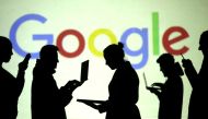 Silhouettes of laptop and mobile device users are seen next to a screen projection of Google logo in this picture illustration taken March 28, 2018. Reuters/Dado Ruvic