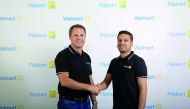 Walmart CEO Doug McMillon (L) and Flipkart co-founder and CEO Binny Bansal shaking hands at an event in Bangalore on May 9, 2018, as a deal was announced for Walmart to buy a stake in Flipkart. AFP photo / Walmart