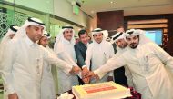 Sheikh Dr Khalid bin Thani bin Abdullah Al Thani (third left), Chairman and Managing Director of QIIB; Dr Abdulbasit Ahmed Al Shaibei (third right), CEO of QIIB; and Jamal Abdallah Al Jamal (left), QIIB’s Deputy CEO cutting the celebration cake with other