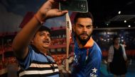 An Indian visitor takes a selfie with the newly unveiled wax statue of Indian cricketer Virat Kohli at the Madame Tussauds Delhi in New Delhi on June 6, 2018. / AFP / MONEY SHARMA