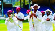 Shane Dowrich (L), Shannon Gabriel (2L), Roston Chase (2R) and Devendra Bishoo (R) of West Indies celebrate winning on day 5 of the 1st Test between West Indies and Sri Lanka at Queen's Park Oval, Port of Spain, Trinidad, on June 10, 2018. / AFP / Randy B