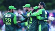Pakistan's Sarfraz Ahmed (2R) celebrates with Pakistan's Shoaib Malik (R) and Pakistan's Shadab Khan (L) following the first Twenty20 International cricket match between Scotland and Pakistan at the Grange Cricket Club in Edinburgh, Scotland, on June 12, 