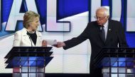 FILE PHOTO: Hillary Clinton reacts as rival Bernie Sanders tries to hand her a piece of paper during a Democratic debate hosted by CNN and New York One at the Brooklyn Navy Yard in New York, April 14, 2016. ( Reuters)