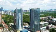 This photo taken on July 20, 2018 shows a 108-meter-high (350 feet) artificial waterfall on the facade of the Liebian International Building (L) in Guiyang in China's southwestern Guizhou province.  AFP