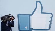 A videographer shooting the side of Facebook Like Button logo displayed at the entrance of the Facebook Headquarters in Menlo Park, California, May 18, 2012 (AFP) 