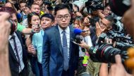 Andy Chan (C), founder of the Hong Kong National Party, is surrounded by members of the media as he leaves the Foreign Correspondents' Club (FCC) in Hong Kong on August 14, 2018. AFP / Philip Fong
 