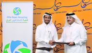 Abdullah Ibrahim Al Suwaidi (left), Chairman Elite Paper Recycling Company and Faleh bin Mohammed Al Naeimi, Chairman and Managing Director of Qatar Post, exchanging the documents after signing the cooperation agreement at Qatar Post headquarters in Doha,