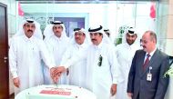 QIIB Chairman and Managing Director Sheikh Dr Khalid bin Thani bin Abdullah Al Thani (second left) along with other board members cutting a ceremonial cake marking the opening of QIIB’s The Mall branch, yesterday.