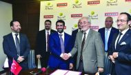 Salah Al Hammadi (third left), Deputy Chief Executive Officer of Al Meera Consumer Goods Company, shakes hands with  Murat Gigin (third right), Chairman of Tekzen, a Turkish Corporation and part of Tekfen Group,as other officials look on, after signing an