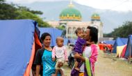A family is seen outside their tent at a camp for displaced victims of the earthquake and tsunami in Palu, Central Sulawesi, Indonesia, October 9, 2018. REUTERS/Jorge Silva
