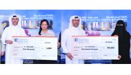 Al Dana savings scheme winners receiving the prize cheques.