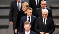 French President Emmanuel Macron, German President Frank-Walter Steinmeier and German Chancellor Angela Merkel arrive to attend a ceremony at the lower house of parliament Bundestag in the Reichstag building in Berlin to mark National Mourning Day, German