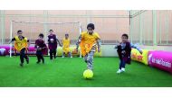Young kids play football at the Qatar Football Association (QFA) pavilion at Darb Al Saai. 
