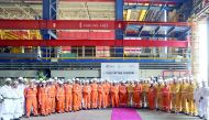 Employees of N-KOM posing for a group photo after marking the steel cutting ceremony for the first ever offshore living quarters to be fabricated in Qatar.