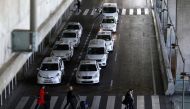People carry their belongings past parked taxis during an open-end strike against VTC regulations outside Terminal 4 at Adolfo Suarez Barajas airport in Madrid, Spain, January 21, 2019. Reuters/Sergio Perez