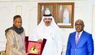 Mohamed bin Ahmed bin Towar Al Kuwari (centre) presenting a memento to Sedou Coulibaly during the event.