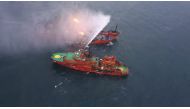 An aerial view from a helicopter shows a rescue vessel during a fire-fighting operation following an accident involving two ships, which caught fire in the Kerch Strait near the coast of Crimea in this handout photo released by Russian Emergencies Ministr