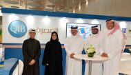 Sultan bin Rashid Al Khater, Undersecretary of the Ministry of Commerce and Industry; and Nama Center Acting Executive Director, in a group photo alongside QIB’s staff at the QIB’s pavilion at the exhibition.