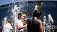 Children play in a fountain as they cool down from the heat on day 11 of the Australian Open tennis tournament in Melbourne on January 24, 2019. AFP / Jewel Samad 