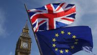 (FILES) In this file photo taken on March 25, 2017, an EU flag and a Union flag held by a demonstrator is seen with Elizabeth Tower (Big Ben) and the Houses of Parliament as marchers taking part in an anti-Brexit, pro-European Union (EU) enter Parliament 