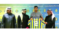 Al Gharafa’s new signing Elias Hassani (third, right) displays his jersey as he poses for a group photo along with officials of the club. 