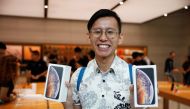 FILE PHOTO: Singaporean Daniel Lim, 23, the first in line to buy the newly released iPhones poses with his purchases at the Apple Store in Singapore, September 21, 2018. Reuters/Edgar Su