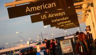This December 9, 2013 photo shows American Airlines and US Airways signs stand next to each others at Denver International Airport, Colorado. AFP/Emmanuel Dunand