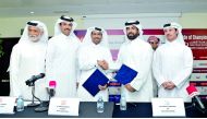 Dr Abdulaziz Al Kuwari (centre), President, Qatar Cycling Centre (QCC); and Rashid Ali Al  Mansoori, CEO, Qatar Stock Exchange (QSE), exchanging documents after the signing ceremony yesterday, as (from left) Abdullah Al Hammadi, from QCC; Ali bin Towar bi