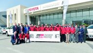 Officials posing for a group photo with the members of the TOYOTA GAZOO Racing in Doha.